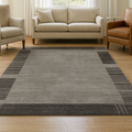A modern geometric gray carpet featuring a sleek design with black accents on a marble floor.